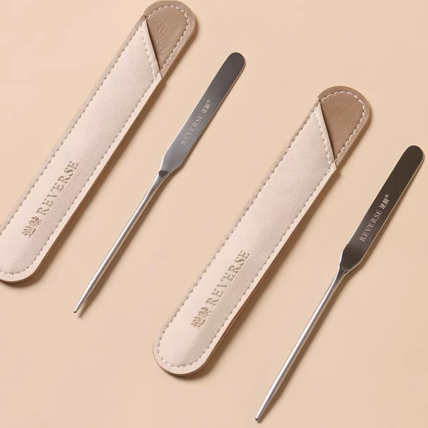 Three stainless steel spatulas with leather cases neatly arranged.