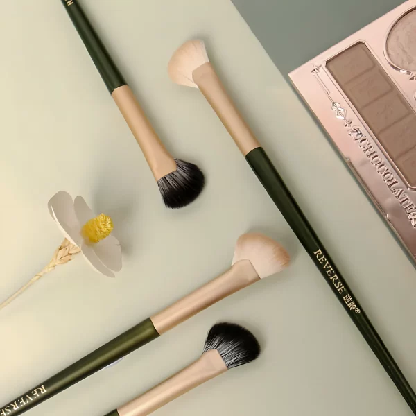 Fan-shaped nose contour brushes in light and dark bristle variations, ideal for precise and natural makeup application