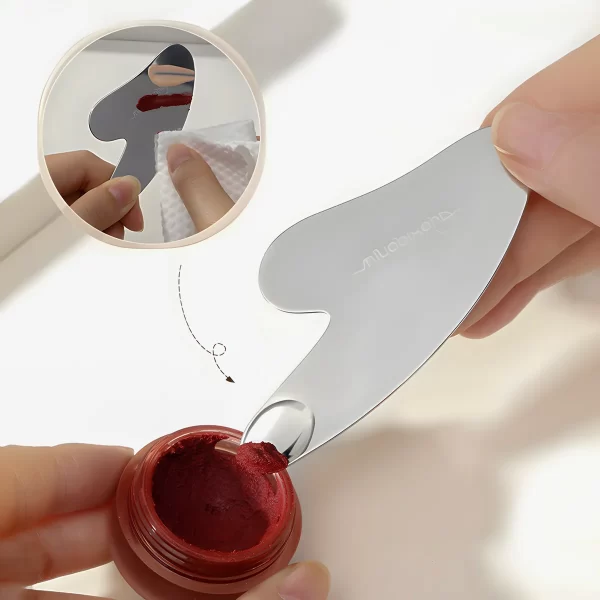 The spatula being used to scoop makeup cream from a jar, showing its practical design.